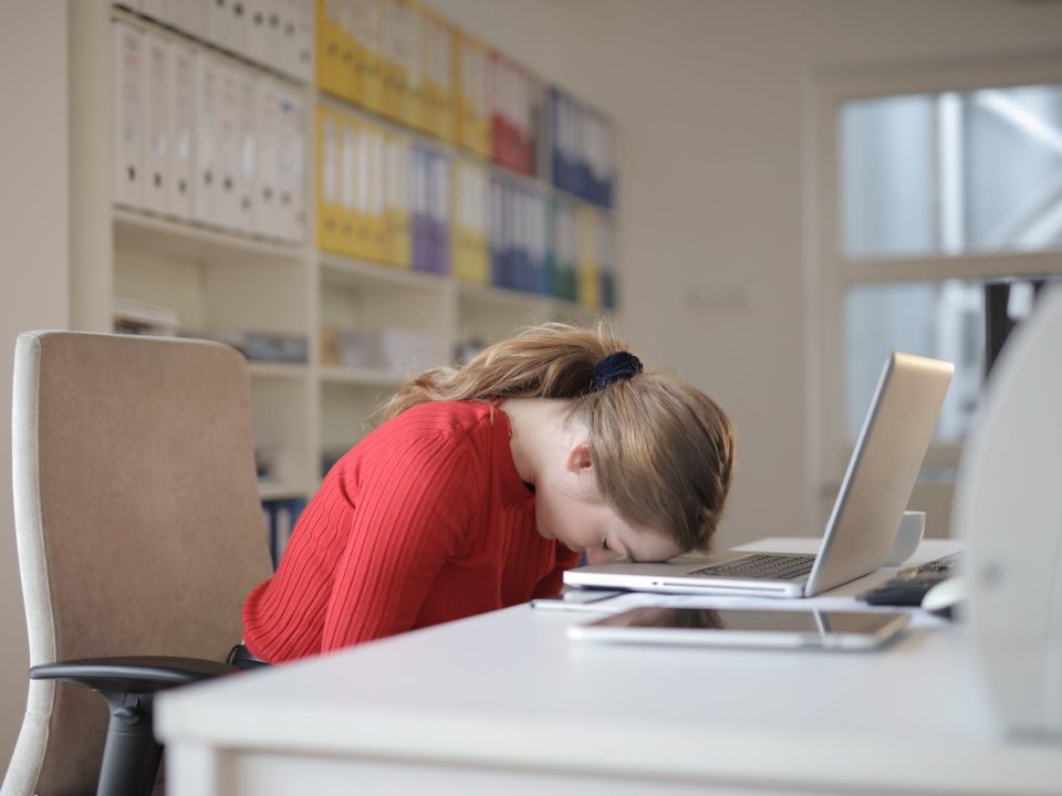 woman sitting on chair while leaning on laptop